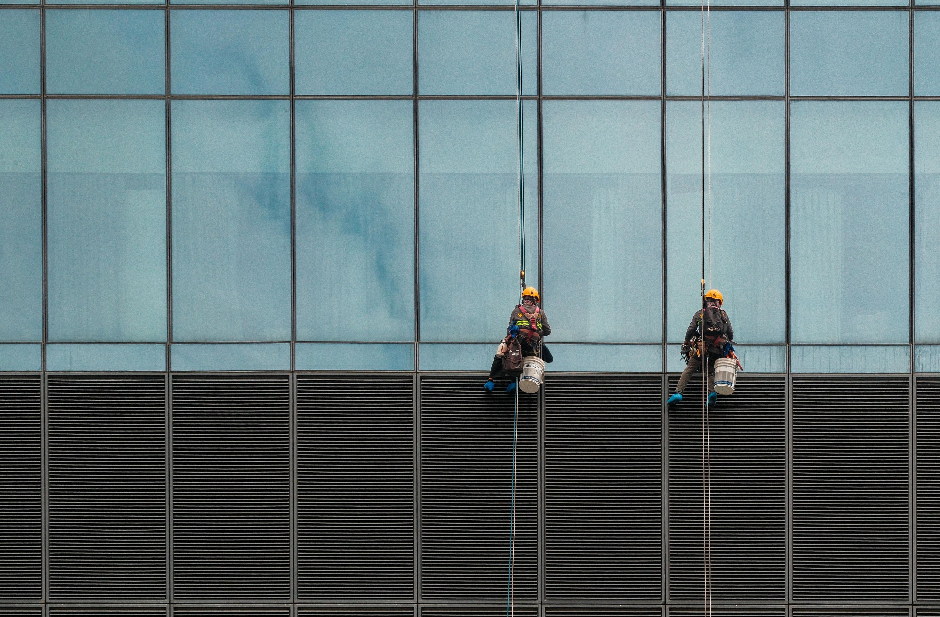 Commercial rope access technicians working on a high-rise building